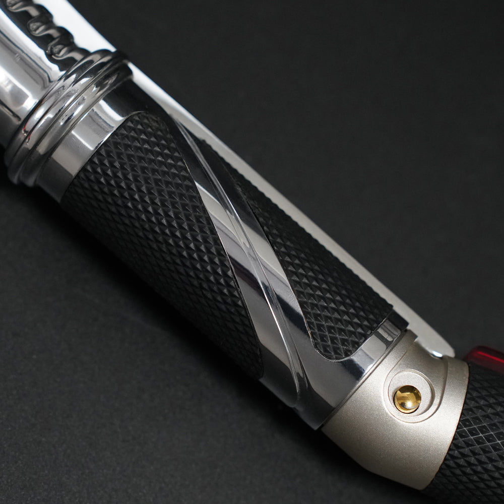 Close-up of the Dooku textured black grip with polished chrome inlay and gold button