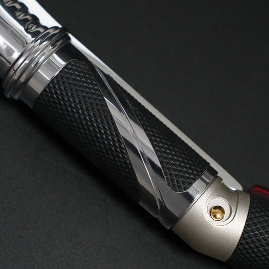 Close-up of the Dooku textured black grip with polished chrome inlay and gold button